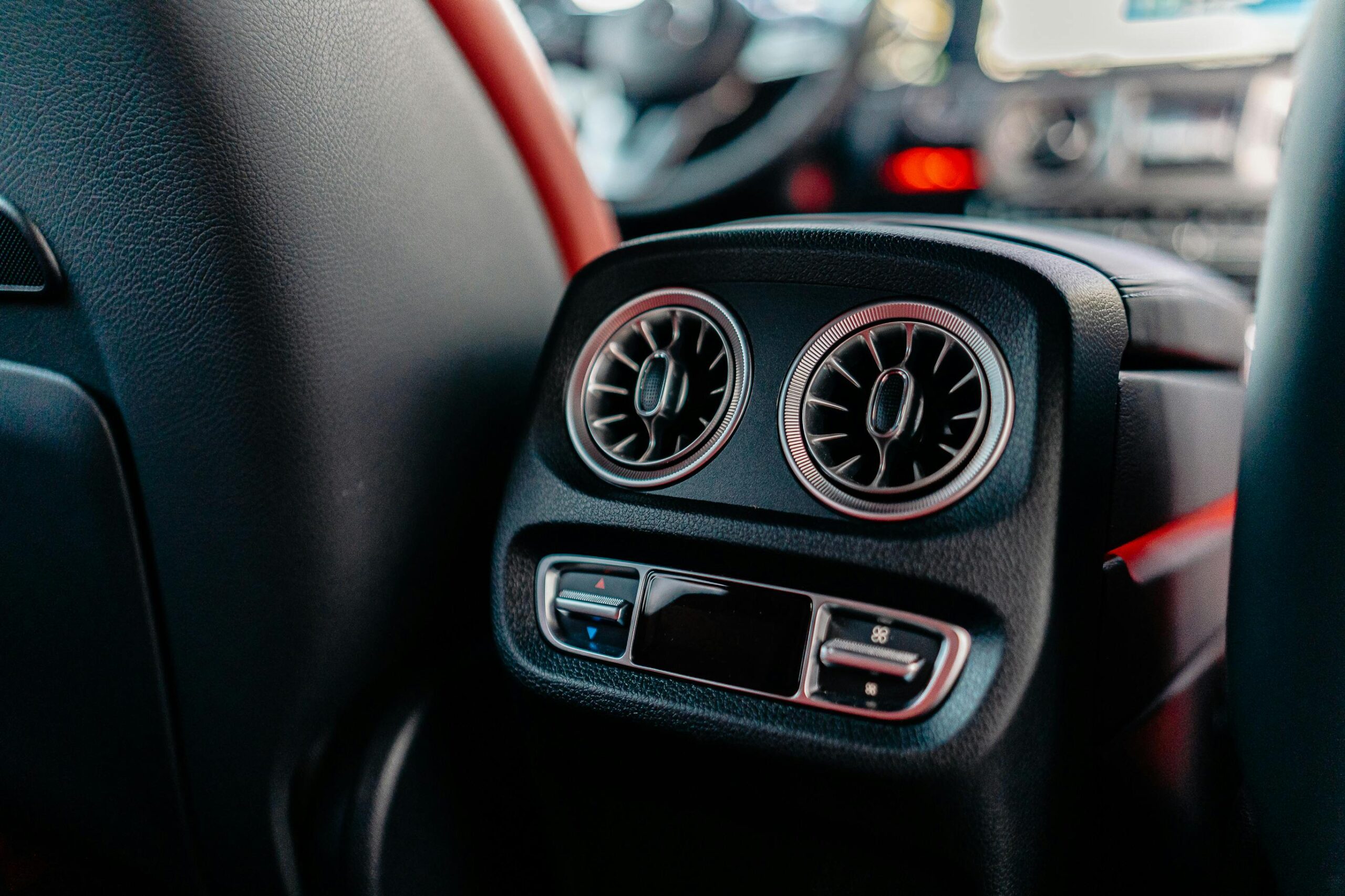 Close-up of a luxury car's air conditioning vents and controls, highlighting interior design.