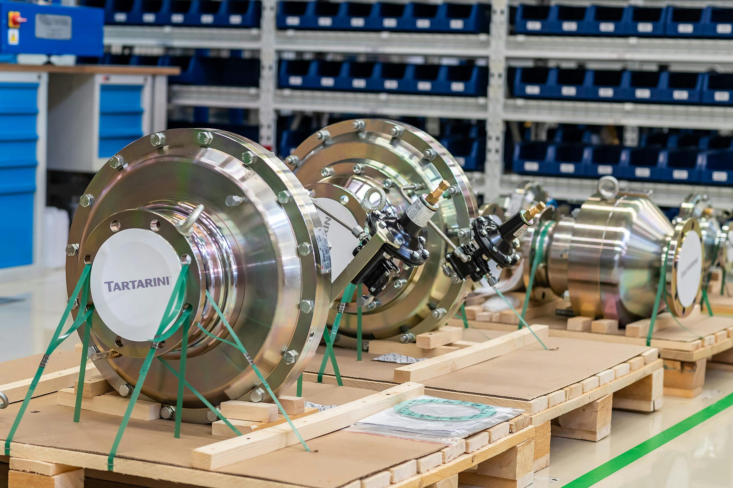 Large industrial valves stored in an organized workshop environment.